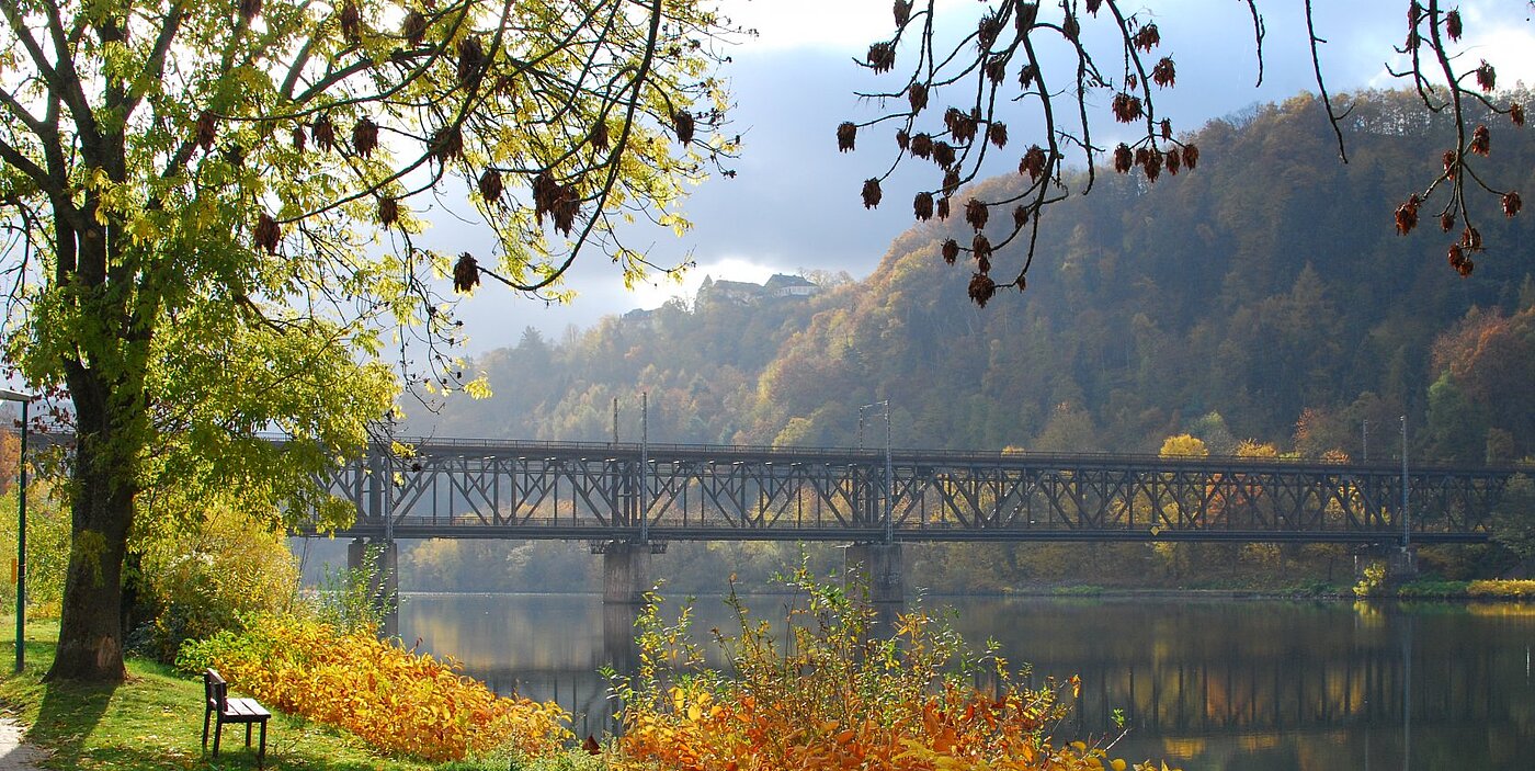 Doppelstockbrücke zwischen Bullay und Alf im Herbst, Uferweg mit Bank an der Mosel